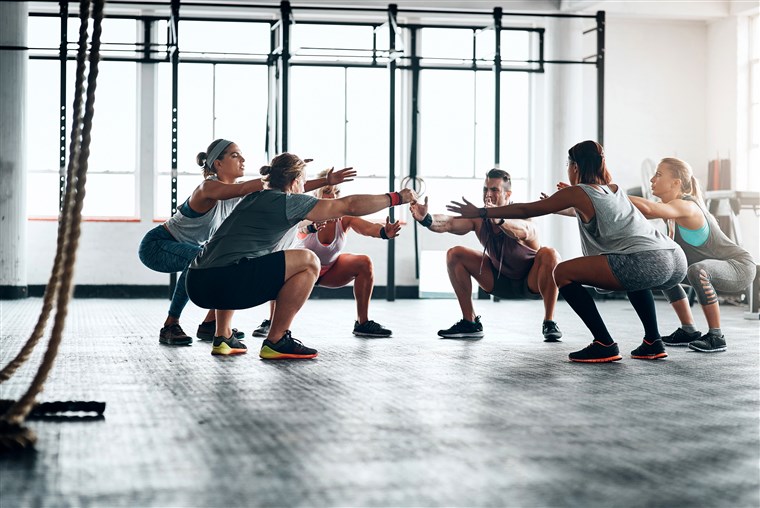 women and man squatting in studio 